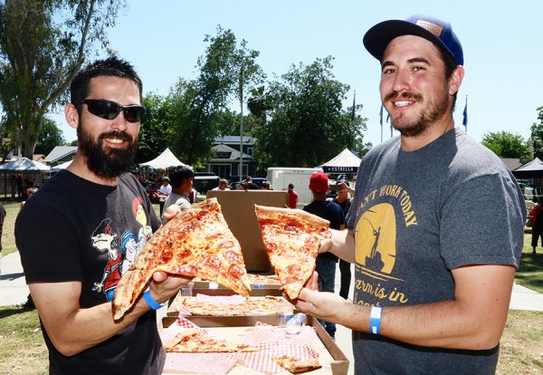 David Paramo and Jeremy Simon show off what is left of 28-inch pizza devoured in 10 minutes.